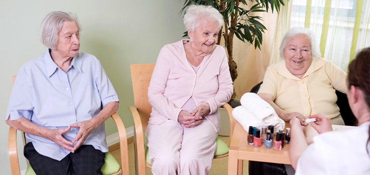 Seniorinnen lassen sich die Nägel lackieren