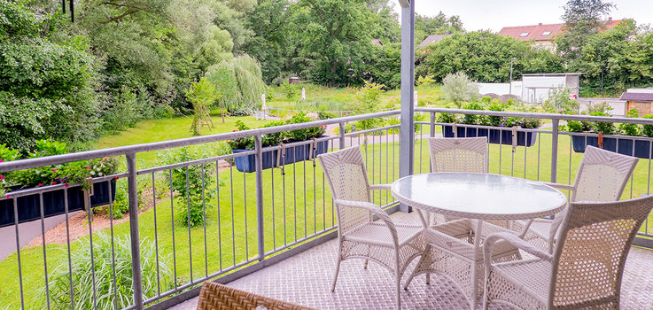 Balkon mit Sitzgruppe und Blick auf Park