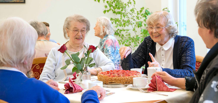 Seniorin schneidet Kuchen an